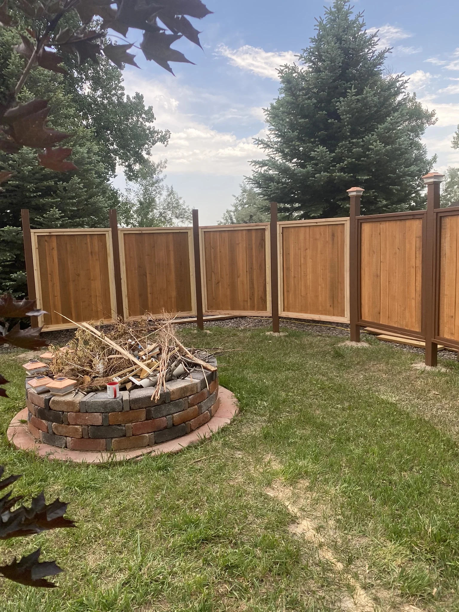 Curved cedar fence around a backyard fire pit
